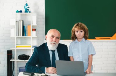 Öğretmen ve çocuk sınıfta. Eğitim konsepti. Okul öğrenme konsepti. Erkek ilkokulu. Yaşlı ve Genç