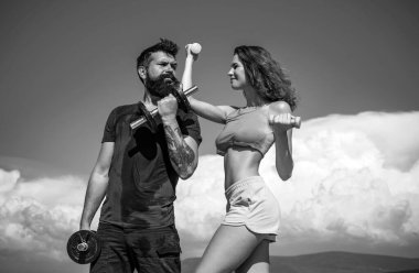 Sportif kadın ve erkek, takım. Spor, halter ve spor, birkaç spor. Sportif seksi çift halterleriyle egzersiz yapıyor. Spor fitness kızı. Aktif çift dışarıda egzersiz yapıyor.