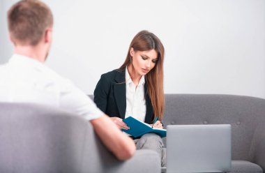 İki işçi ofiste projeyi tartışıyor. Çift iş arkadaşları dizüstü bilgisayar kullanıyor, ofiste çalışmak hakkında tartışıyorlar.