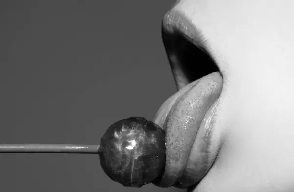 性感红唇加糖果印刷在艺术设计中 嘴里含着红棒糖 光滑的女人的嘴唇舔舔吸棒棒糖 性感性感的嘴与糖果的概念享受美丽的女性唇 — 图库照片