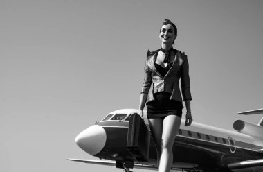 Hostes. Seyahat ve jet yolculuğu. Kadın ve ticari uçak. Mavi üniformalı çekici hostes portresi. Hostes ve seyahat zamanı. İş adamları ve ticari jet uçakları