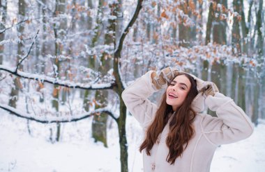 Modeli şık kazak ve eldiven giyiyor. Neşeli güzellik genç kadın eğlenmek kış Park