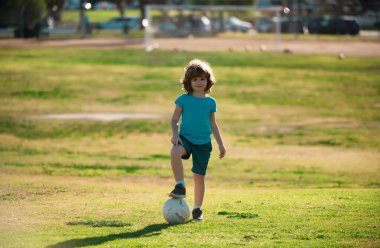 Futbolcu çocuklar, çocuk dışarıda futbol oynuyor. Futbolcu çocuk tekme atıyor. Futbol oyuncuları hareket halinde. Çocukluk ve spor. Küçük futbol şampiyonu.