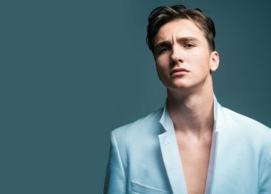 Moda erkek modeli. Gri arka planda izole edilmiş seksi bir adam.