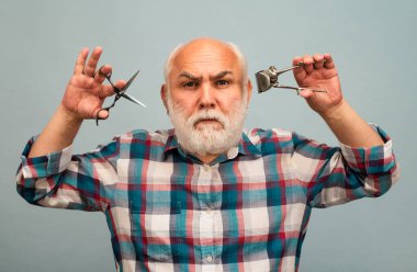 Berber makası ve saç makasıyla orta yaşlı berber. Klasik berber, tıraş.