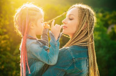 Saçlarını ören anne ve kızı. Örgü ören güzel bir kız çocuğu. Saç örgüsü modaya uygun.