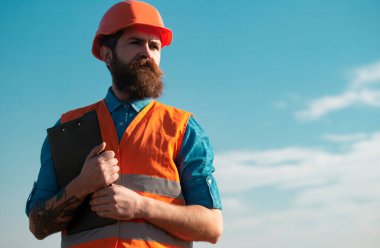 İnşaat işçisi inşaat alanında. Geliştirme ve yenileme. Zalim bir insan müteahhidi. Üniformalı mühendis.