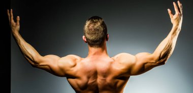 İnsan Gücü. Mükemmel Omuzlar ve Sırt Kasları. Kaslı Adam Güç gösteriyor, Arka Görüş. Seksi bir vücut. Güçlü Omuzlar. Kas gücü. Güçlü ve seksi.