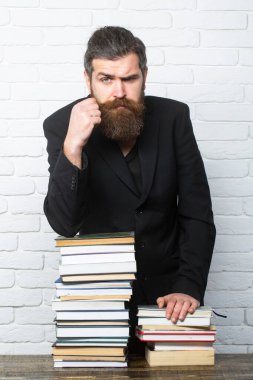 Kitap yığını olan komik bir öğretmen ya da profesörün portresi. Üniversitede ya da üniversitede. Olgun bir öğretmen düşünüyorum. Olgun profesör, orta yaşlı öğretmen, sakallı eğlenceli adam.