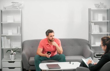 Psikolog, genç adamın erkek sorunlarını çözmesine yardım ediyor. Psikolojik sorun, terapi. Orta yaşlı adam krizi