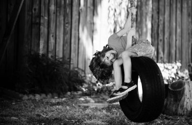 Dışarıdaki parkta zincirli salıncakla eğlenen komik çocuk. Çocuk dışarıda oyun oynuyordu. Çocuklar anaokulunun bahçesinde oynuyor. Çocuk dışarıda oyun oynarken eğleniyor.