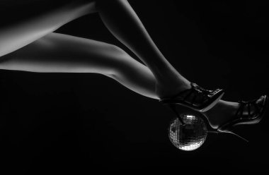 Yüksek topuklu disko topu. Parti bacakları. Disko etkinliği. Altın renkli disko topu olan kadın topukları. Konsepti kutla