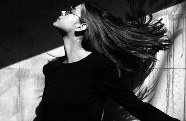 Havalı yaz bahar kıyafetleri içinde güzel bir kadın. Şehvetli esmer kadının saç hareketi. Kadın stili model şehir caddesinde yürüyor. Yaz trendi, moda kıyafeti