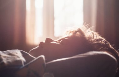 Yatakta uyuyan çocuk. Sessiz bir uyku. Rahat çocuklar sabahları uykulu olurlar. Yüzünü kapat.