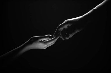 İki el uzanıyor. Şefkat ve şefkat siyah arka planda el ele tutuşur. Parmaklarınla romantik dokunuş, aşkım. Adem 'in el yapımı