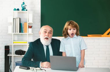 Okulda öğretmen ve öğrenci. Sınıfta dizüstü bilgisayarlı bir öğrenci. Çevrimiçi eğitim