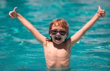 Çocuk yüzme havuzunda yüzüyor. Havuzdaki aktiviteler, yüzen ve oynayan çocuklar, mutluluk çocukları ve yaz zamanı