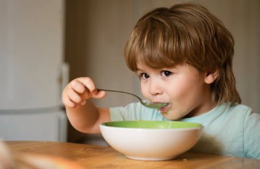 Evde sağlıklı yemek yiyen çocuk çocuk. Mutlu çocuk kahvaltı eder. Evde kahvaltı güzel çocuk portresi. Mutfakta meyve püre yiyen mutlu sevimli bebek gülümseyen. Çocuk yeme