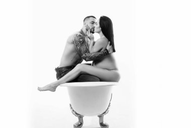 Birbirine aşık çiftler. Aile bağı. Hamilelik. Hamile kadın kaslı maço erkeği öpüyor. Banyodaki adam ve kız beyazda izole edilmiş. Hijyen ve sağlık hizmetleri. gelecekteki hayat. Sevgililer Günü. Annelik.