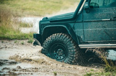 Kötü çakıllı yolda arazi aracı. Off-road yarışında çamur ve su sıçraması. Dağ yolunda off-road yolculuğu