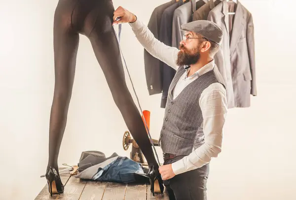レトロな古いファッションドレスメーカーは 女性のセクシーな長い足を測定します シームレスな男 ドレスメーカーの縫い目男性は女性のための服を縫います ファッション ドレスメイキング プロのテーラー モデルが付いているドレスメーカー — ストック写真