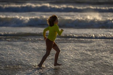 Happy child playing in the sea. Kid having fun outdoors. Summer vacation and healthy lifestyle concept. Cute kids having fun on beach in summer. Happy child playing in the sea. Summer vacation