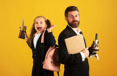 Back to school, student girl with uniform. Cheerful smiling little girl in school uniform having fun in studio. Portrait of amazed excited happy pupil school girl and tutor with success having fun