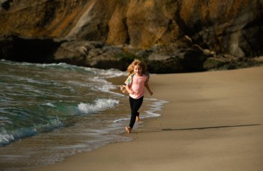 Kids running outdoors. Run and healthy sport for children. Child running on sea, kids fitness. Little athlete in training. Runner exercising, jogging for kids