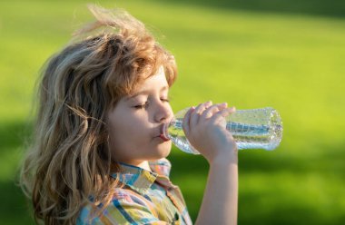 Evcil hayvan şişesinden su içen çocuğun portresini kapat.