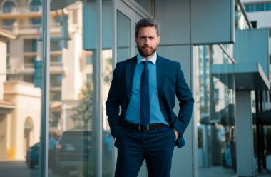 Ofisin dışında duran kendinden emin bir iş adamının portresi.