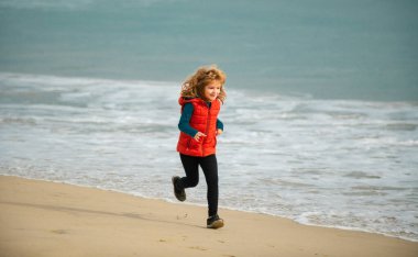 Kid running on beach. Happy child run in sea on summer vacation. Morning running with children