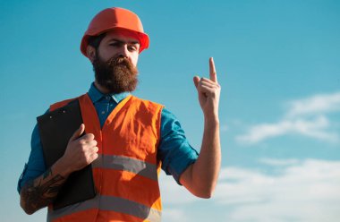 Construction worker in uniform and safety equipment have job on building. Improvement and renovation. Brutal man builder. Engineer builder in uniform