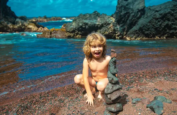 石のピラミッドを作っている興奮した子供の男の子安定性 バランスを象徴する小石のビーチで — ストック写真