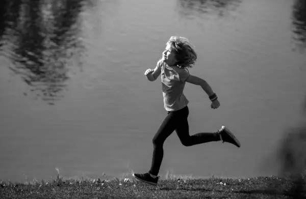 Child boy runners run in park. Outdoor sports and fitness for children, exercise outside