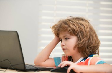 Ders sırasında dizüstü bilgisayara bakan okul çocuğunun portresi. Çocuk için eğitim ve öğrenim