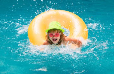 Küçük çocuk havuzda yüzüyor. Çocuk yüzme havuzunda dinleniyor.