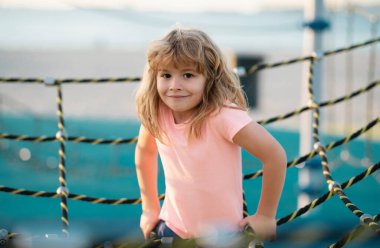 Çocuk parkında oynarken sevimli küçük çocuk komikliği. Yaz, çocukluk, eğlence ve çocuk konsepti