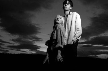 Genç aşık çift dramatik gökyüzünde birlikte zaman geçirir. Erkeğin kucaklaması ve şehvetli bir kadını öpmesi