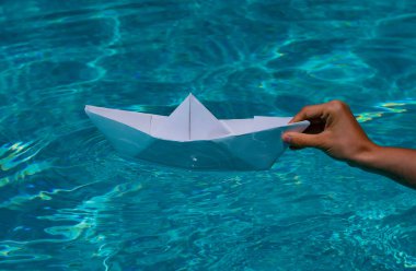Paper ship in hand. Hand and paper boat. Origami paper boat