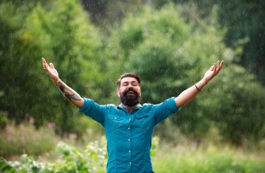 Sonbahar yağmurlu hava konsepti. Su geçirmez giysi. Yağmur altında mutlu bir adam