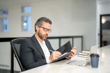 40 'ların yakışıklı iş adamı ofiste dizüstü bilgisayarla çalışıyor. Gri saçlı, olgun iş adamı yönetmeni dizüstü bilgisayar kullanıyor. Ofis işyerinde milenyum müdürü. CEO ofis çalışanları. Ofisteki iş adamları.