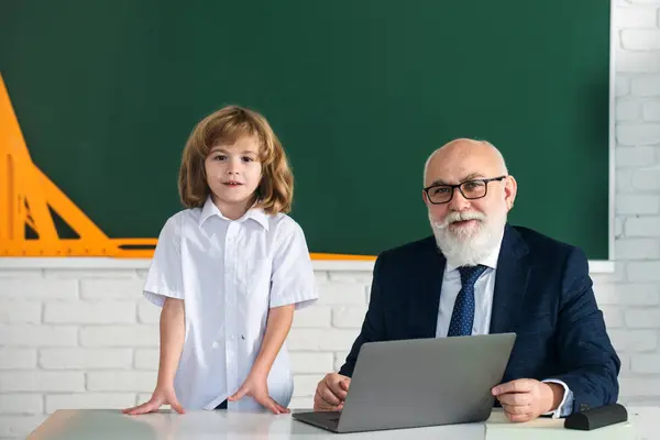 stock image Teacher sharing experiece with pupil in classroom. Education concept. School learning concept. Boy elementary school. Old and Young