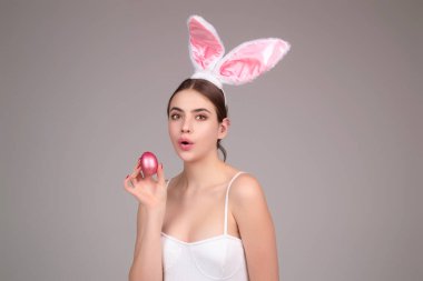 Easter bunny girl wear easter fluffy bunny ears hold easter eggs, isolated studio background. Eater portrait of female bunny