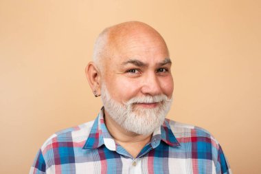 Mutlu kıdemli adam gülümsüyor. Yaşlı büyükbaba, emekli dede, emekli konsept. Stüdyo arka planında gri sakallı, olgun kel bir adam. Yaşlı, beyaz, yaşlı bir adamın portresi.