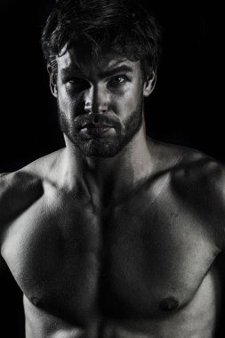 Seksi çıplak kaslı adam. Siyah üzerine seksi yakışıklı playboy. Yakışıklı kaslı adam rahatlıyor. Çıplak kaslı seksi bir adamın portresi. Güçlü atletik adam. Uygun erkek modeli