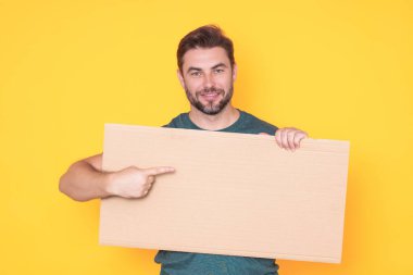 Stüdyodaki adam reklam panosundaki boş panoyu işaret ediyor. Kopyalama uzayı olan boş tabela. Reklam konsepti. Fotokopi alanı olan reklam panosu, boş model. Boş tabela, pano