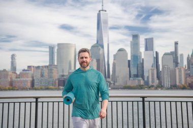 Spor formundaki adam New York 'ta spor yapıyor. Fitness adamı. Sporcu, kardiyo için antrenman yapıyor. Spor salonu açık havada. Adam dışarıda çalışıyor. New York parkında aktif yaşam tarzını seven bir adam.