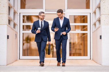 Insurance agent. Two business team men. Man in suit walking across on american office outdoor clipart