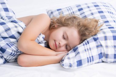 Çocuk evde yatakta uyuyor. Yatma zamanı, çocuklar uyuyor. Çocuk yastıkta uyuyor, sağlıklı bir uyku çekiyor.