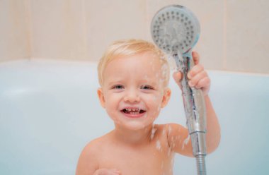 Şirin Bebek Banyoda saç yıkıyor. Sağlık ve günlük rutin için kavram. Bebek duş aldıktan sonra bir havlu ile. Çocuk banyo